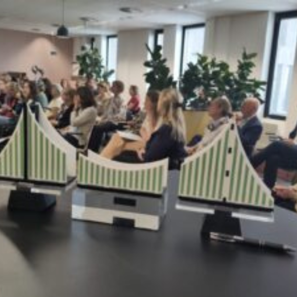 op de voorgrond een brug in drie delen met op de achtergrond deelnemers van het inspiratie-event